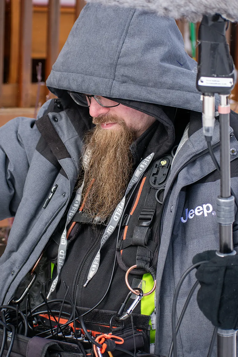 A person with a beard is holding electronic equipment.