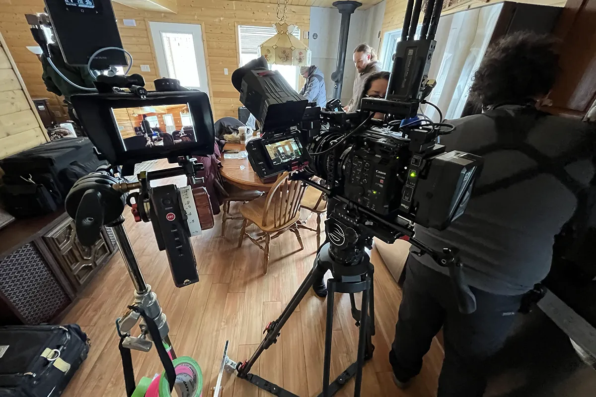 People and movie equipment in a small room.