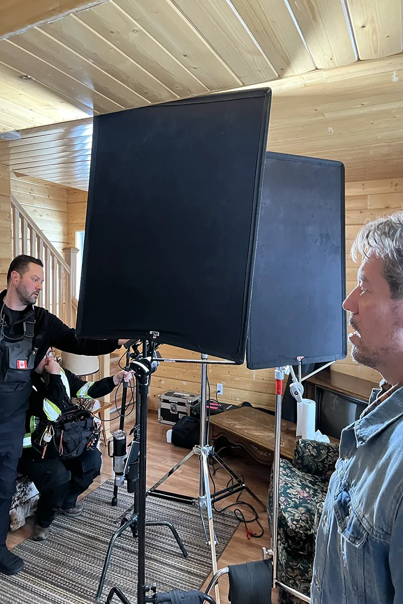 Two people standing in a room with movie equipment.